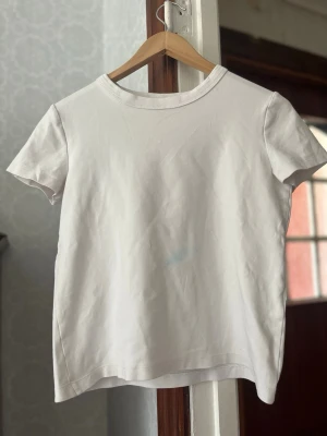Klassisk vit t-shirt i bomull - Har en liten blå fläck på framsidan därav priset.