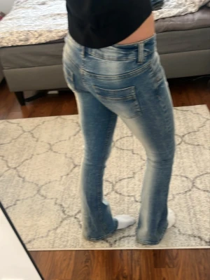 Snygga jeans från Gina i nyskick! - Säljer ett par blå bootcut jeans från Gina. Jeansen har klassisk femficksmodell och låg midja. Perfekta för dig som gillar en avslappnad men trendig look.