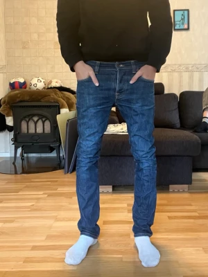 Mörkblå slim fit jeans - Säljer dessa sjukt snygga jeansen från Nudie i den populära modellen Grim Tim. Färgen heter Dry Open Navy. De är i superbra skick och i storlek 31/32 men lite små i storleken. Personen på bilden är 180 cm och väger 67 kg men är lite små på han.