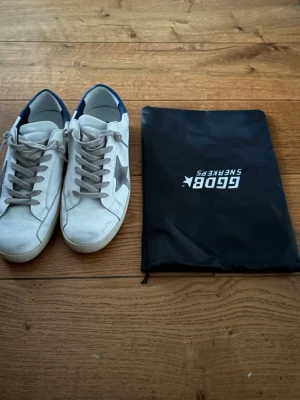 Golden Goose skor - Helt oanvända och snygga vita Golden Goose skor. Säljer skorna för dem va för små för mig. Skorna har grå skosnören och klassisk låg siluett. Tillverkade i läder med slitna detaljer för en trendig look. Medföljer dustbag, Ingen skolåda. Pris kan diskuteras vid snabb affär! 🙌