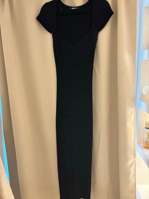 Svart ribbad långklänning Gina Tricot - Svart långklänning från Gina Tricot i ribbad bomullsmix. Klänningen har korta ärmar och en snygg v-ringad urringning. Perfekt för dig som gillar en enkel men stilren look. Använd 2 gånger. Köparen står för frakten💕