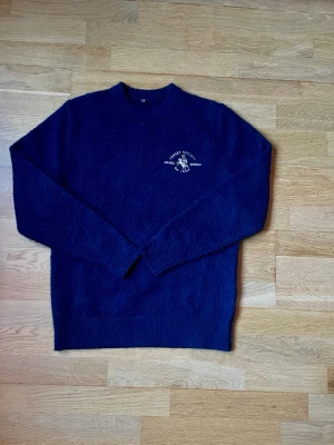 Escendi sweater - En aldrig använd Mörkblå stickad sweater ifrån Escendi, med broderad logga och text på bröstet samt stor vit Escandi text på ryggen. Sweatern är i kaschmir och är perfekt för dig som gillar stilrena och unika plagg. Sweatern är i storlek XS, och har aldrig använts pga två i julklapp. Köpt för 899kr. Hör av er om ni vill ha mått eller annat👌🤩