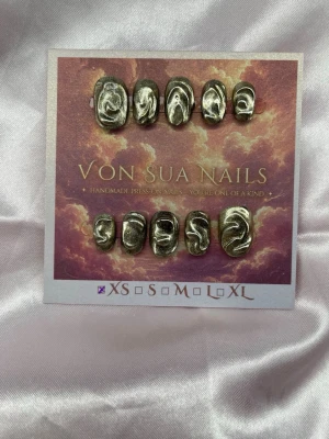Midas (XS);ExtraShortOval  - Unika handgjorda press-on naglar i metallic silver/guld med abstrakta swirl-mönster. Naglarna har en extra kort, oval form och en glansig finish som ger en cool och trendig look. Perfekt för dig som vill sticka ut med snygga detaljer.XS: 14 mm, 11 mm, 11,5 mm, 10 mm, 8 mm