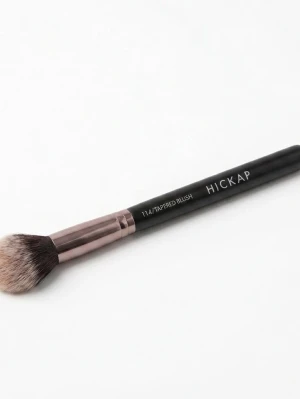 Hickap Tapered Blush sminkborste - Säljer en Hickap Tapered Blush sminkborste med svart skaft och metallisk roségulddetalj. Borsten har mjuka, täta borststrån i en avsmalnande form som passar perfekt för rouge eller contouring. Stilren design och lätt att använda för en jämn applicering.