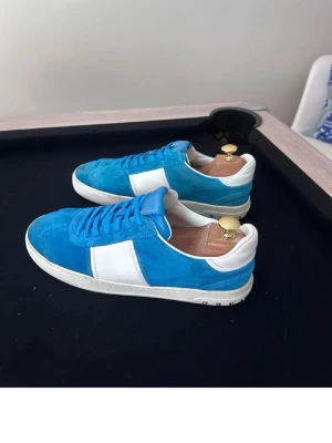 Valentino Flycrews - Snygga sneakers i blå mocka med vita detaljer och vit sula. Skorna har klassisk låg profil och blå skosnören. Perfekta för dig som vill ha en färgklick till outfiten. Tidlös design med bekväm passform. Slut överallt kan ej hitta bättre skick för bättre pris 