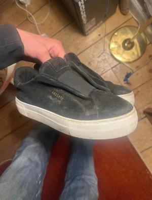 Svarta mocka sneakers 37 - Axel Arigato - Säljer ett par svarta sneakers från Axel arigato i mocka. Storlek 37 och tror dom är Unisex men är inte helt säker. Saknar både kvitto och låda. Kan gå ner i pris vid snabb affär.