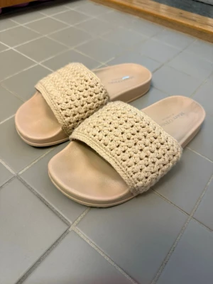 Beige flätade sandaler Marc O'Polo - Snygga beige sandaler från Marc O'Polo med bred flätad rem i textil och mjuk sula. Perfekta för sommaren. Använd några enstaka gånger men dessvärre färgade på innersulan, dock ej på själva remmen eller på sidorna endast innersulan.