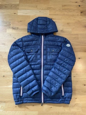 Moncler Douret jacka  - Säljer en Moncler Douret | storlek 4=L Men sitter mer som M| jätte fin i skicken| den är i en marin blå färg | kom dm vid frågor 