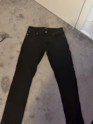 Jeans - Säljer ett par svarta skinny jeans med klassisk femficksmodell och smal passform. Jeansen har knapp- och dragkedjestängning samt raka ben. Perfekta till en enkel t-shirt eller hoodie.
