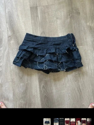 Denimkjol med volanger  - Suuuuper snygg lågmidjad jeanskjol med volanger. Eftertraktad och slutsåld. Har inbyggare shorts under. Mkt fint skick, dock skrynklig 💕köpt för 400kr