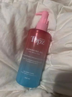 Topz Cleansing Gel 300 ml - Topz Cleansing Gel är en rengöringsgel för daglig användning som tar bort smink och rengör huden. Kommer i en snygg rosa-blå pumpflaska på 300 ml. Passar alla hudtyper och är parfymfri med ingredienser som niacinamid och hyaluronsyra. Använt 3-4 gånger.