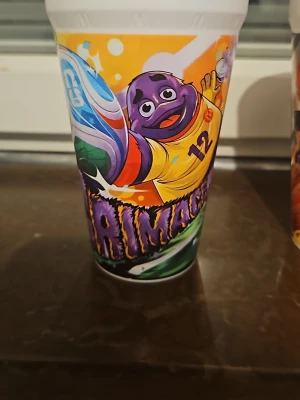 Vm muggar - Säljer 4 World cup muggar från McDonald's med sportigt motiv. Ena muggen har en lila maskot i gul tröja och den andra visar en fotbollsspelare i orange och blått. Perfekta för samlare eller som roliga dryckesglas. Muggarna är dekorerade med livfulla färger och coola illustrationer.
