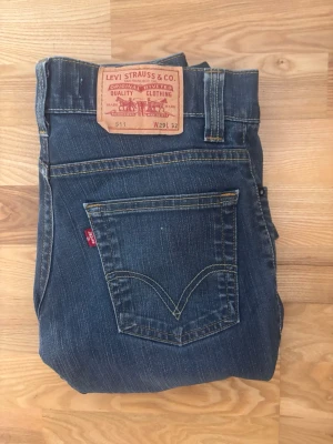 Levi's 511 navy mörk blå jeans herr W29 L32 - Säljer ett par klassiska blå Levi's 511 jeans med rak passform och fem fickor. Jeansen har snygga slitningar och kontrastsömmar samt den ikoniska röda Levi's-lappen på bakfickan. Tillverkade i bomull med en tidlös look.