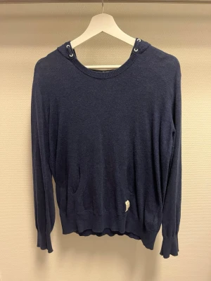 Massimo dutti hoodie - Mysig mörkblå hoodie med huva och långa ärmar. Tröjan har ribbade muddar och snygga ljusbruna mockalappar på armbågarna. Perfekt för en avslappnad stil och enkel att matcha med jeans eller joggers. Den är storlek 158-166cm.