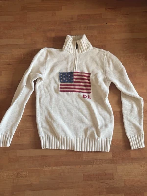 Vit stickad Ralph Lauren  - Vit stickad Ralph Lauren tröja med halv dragkedja ochg hög krage. (Barnstorlek)