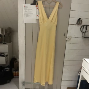 Gul balklänning Maxiklänning - Säljer denna superfina gula balklänning från abercrombie & fitch då jag har hittat en annan 🙈Är i storlek S. V ringad framifrån med öppen rygg 🤩Har väldigt svaga små fläckar fram (se bild) bör vara lätt att få bort