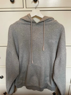 Grå VETEMENTS hoodie - Säljer en ljusgrå designerhoodie från VETEMENTS, från deras PRET-A-PORTER hoodie collection designad av Demna Gvasalia. Hoodien är i storlek S, men VETEMENTS gör sina plagg oversized, så enligt mig passar den bäst för en M. Den har tryck på båda brösten samt på luvan och har en clean, oversized passform. Hör gärna av dig vid frågor!