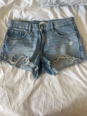 Ljusblå denimshorts med slitningar - Säljer ett par ljusblå jeansshorts från gina för att shortsen är för små💕