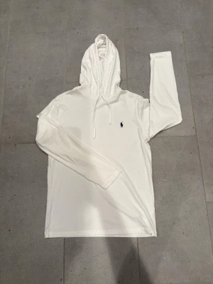 Polo Ralph Lauren hoodie  - En fin lite tunnare Ralph lauren tröja. Endast använd en gång, även tvättad en gång som man kan se där det lossnat lite. Storlek S. Köpt för 1200kr.  Längd 67cm. Ärm från axel 61cm. Armhåla till armhåla 45cm. Bara att fråga vid funderingar!