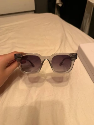 Transparenta fyrkantiga solglasögon - Snygga solglasögon med transparent båge och fyrkantig form. Glasen är mörktonade i grått och ger en modern vibe. Perfekta för dig som vill ha en clean och trendig look till sommaren. Bästa skick aldrig använda 
