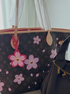 Väska  - Helt ny Neverfull väska med murakami blommor. Väskan är i äkta läder och har röd insida