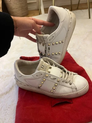 Valentino rock studs  - Säljer mina Valentino skor. Storlek 37 men passar mig som har 37/38. Använda en hel del men alla nitar är kvar och lädret är fortfarande fint. Dom är ej tvättade nu då jag vill lägga upp dom och få dom sålda snabbt men kommer att tvätta snören och skorna innan de skickas. Även smörjas med läder kräm. De ända skavankerna ser man på bild 3. Köptes begagnande för 2500kr, med äktighetskontroll. Dustbagen ingår 