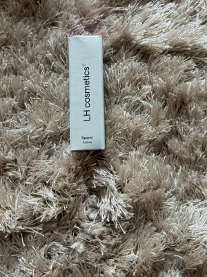 LH cosmetics Sparkl Adore ögonskugga - Säljer en LH cosmetics ögonskugga i färgen Sparkl Adore. Förpackningen är vit med svart text och färgen på skuggan verkar vara skimrande rosa-lila. 
