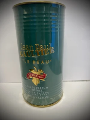 Jean Paul Gaultier Le Beau Parfym - Jean Paul Gaultier Le Beau Eau de Parfum Intense i en stilren grön metallburk med gulddetaljer. Flaskan har en unik design som liknar en manlig torso och rymmer 125 ml. En ikonisk doft med lyxig känsla och elegant förpackning.