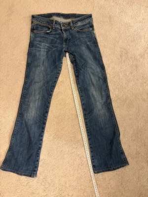 Blå bootcut jeans  - Säljer ett par bootcut Wrangler jeans i storlek W28/L32. Dom har lite slitningar men annars fint skick. 