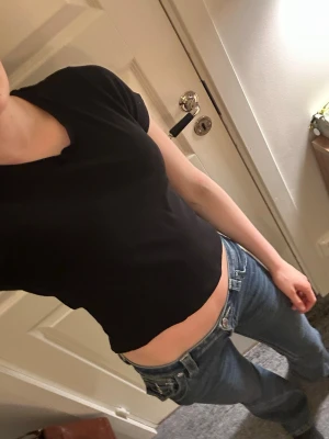 Svart croppad t-shirt - En enkel svart croppad t-shirt med rund hals och korta ärmar. Perfekt till jeans eller kjol för en clean och stilren look. Materialet känns mjukt och stretchigt.