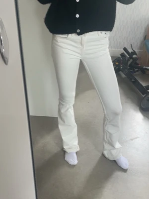 Vita bootcut jeans - Säljer ett par vita bootcut jeans med klassisk femficksmodell och normal midja. Jeansen har en snygg utsvängd passform och är tillverkade i ett stretchigt denimtyg som sitter bekvämt. Perfekta för dig som vill ha en clean och fräsch look. OBS de har lite smuts på sig som knappt syns men inte går bort!💕