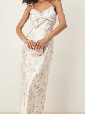 Vit långklänning med blommigt mönster - Elegant långklänning i satin med tunna axelband och blommigt mönster i rosa och grönt. Klänningen har spetsdetaljer vid urringningen och en smickrande, figurnära passform. Perfekt för sommarens alla tillfällen❤️ aldrig använt och prislappen är kvar