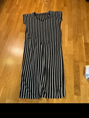 Svartvit randig klänning Vero Moda - Jättefin oanvänd klänning från Vero Moda. Svart med vita ränder och V-ringning. Bekväm och stilren modell som passar både till vardag och festligare tillfällen. Aldrig använd. Material Polyester och Viscose.