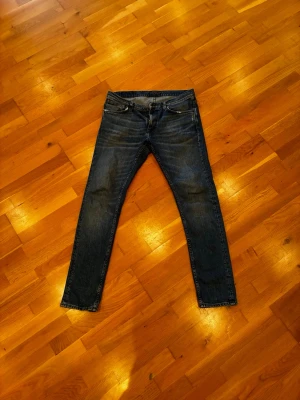 Nudie jeans storlek 33/34 - Snygga mörkblå nudie jeans i 8/10 skick, jeansen är för små för mig och jag är ca 188cm och 85kg. Hör av vid frågor