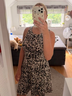 Klänningen  - Säljer en snygg klänning med leopardmönster i svart och beige. Klänningen är inte använd mycket och är i väldigt bra skick. Den passar mig bra som vanligtvis har S