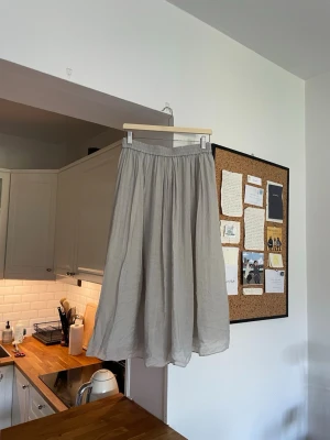 Grön mint långkjol i linne - Luftig och flowy mintgrön långkjol med resår i midjan. Kjolen är tillverkad i linne och har en enkel, stilren design som passar perfekt till varma dagar. Den har en mjuk och naturlig känsla med lätt struktur i tyget.
