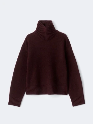 Vinröd stickad tröja med hög krage  - Mysig vinröd stickad polotröja med bred ribbad mudd vid hals, ärmslut och nederkant. Tröjan har en avslappnad passform och långa ärmar. Perfekt för kalla dagar och enkel att styla med jeans eller kjol.