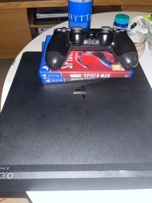 Ps4 med en kontroll  - Kontrollen är ty är sönder och Minecraft har jag tyvärr inte kvar och har ingen anning om spiderman finns kvar 