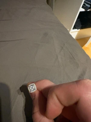 Kvadratiskt örhänge med pärlor - Säljer ett kvadratiskt örhänge i silverfärg med gnistrande pärlor runt hela framsidan. Örhänget har en modern och stilren design som verkligen fångar blicken. Perfekt för dig som gillar att sticka ut med dina accessoarer.