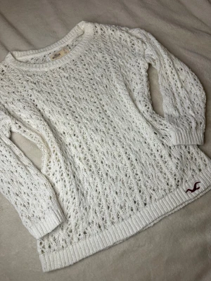 Vit stickad Hollister tröja Vintage - Säljer en skitsnygg vit stickad tröja från Hollister med hålmönster! Sitter jättefint på och är perfekt nu inför hösten! Ärmarna är kortare i modellen, och pris kan diskuteras! Kan även skicka mått privat!💕