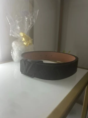 Svart bälte med fint mönster  - Ett riktigt stiligt bälte i färgen svart och som även har svart spänne. Det har ett väldigt unikt och fint mönster. Det är 120cm lång.