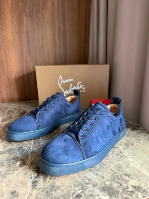 Blå mockasneakers från Louboutin - Snygga blå sneakers i mocka från Christian Louboutin med matchande blå sula och klassisk röd undersida. Lågt skaft, ton-i-ton snörning och diskreta detaljer gör dem perfekta för en trendig streetstyle-look.