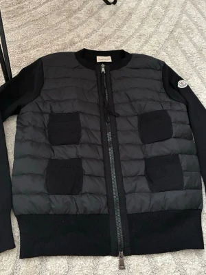 Moncler cardigan  - Säljer vidare min Moncler cardigan till höst/vår i storlek L men skulle säga att den även passar M. Den är knappast använd alltså i mycket fint skick. Kvitto finns. 