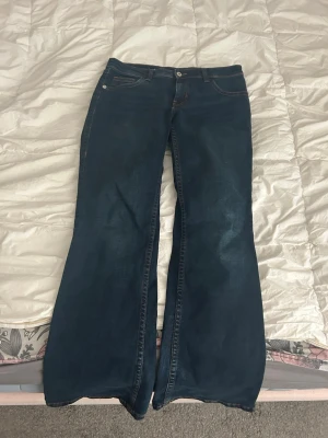 Mörkblå bootcut jeans - Snygga mörkblå bootcut jeans med coolt mönster på fickorna. De är lite stora så blir nästan baggy eller flare (men är inte riktigt en 42 utan mer en 40). Har ett par exakt likadana så finns 2 st!💞💞