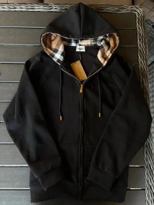 Burberry Hoodie - Säljer en snygg svart hoodie från burberry! Hoodien är i mycket bra skick och har inga defekter. Varm av de mjuka materialet i hoodien. Om ni har några frågor så hör av er😊