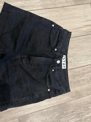 Svarta denimshorts från I.STAY XS - Svarta denimshorts från I.STAY i klassisk femficksmodell. Hög midja och raka ben ger en snygg och tidlös look. Tillverkade i bomull med en liten del elastan för extra komfort. Perfekta för sommaren och enkla att matcha med allt.