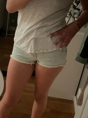 Ljusblå denimshorts - ⚠️Skriv innan ni köper⚠️Säljer ett par ljusblå denimshorts med hög midja och fransig kant. Klassisk femficksmodell med dragkedja och knapp framtill. Jag brukar ha en tröja över, då jag inte gillar högmidjat💞💞