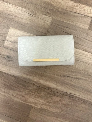 Vit väska axelväska handväska festväska elegant trendig gulddetaljer oanvänd - Säljer denna eleganta vita väska då den tyvärr aldrig kommer till användning 🥹🤍 Helt oanvänd och i jättefint skick!  ✨ Stilren vit design ✨ Guldfärgade detaljer ✨ Fint flätat mönster ✨ Perfekt till fest, middag eller vardag  Köpt från Amazon och säljes för endast 70 kr! 🛍️🤍  🎀 3 FÖR 2 PÅ ALLT JAG SÄLJER! 🎀 Passa på att kika på mina andra annonser – välj 3 saker och betala bara för 2! 🥰✨  Först till kvarn! 🤍