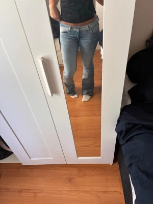Ljusblå bootcut jeans - Säljer ett par ljusblå bootcut jeans med klassisk femficksmodell och låg midja. Jeansen har en snygg tvätt och är tillverkade i denim med lite stretch för skön passform. Perfekta för dig som gillar en avslappnad men trendig stil. Storlek 29/32