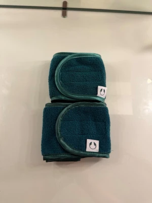 Mörkgröna microfiber hårband  - Två stycken mörkgröna microfiber hårband med kardborrestängning och  kantband. Tillverkade i mjukt, frottéliknande material. Perfekta för att få bort håret under sminkning. 